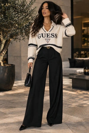 Guess Coordinato • Maglia in maglia morbida e pantaloni in tessuto fluido • Maglia oversize a righe orizzontali bianche e nere con scollo a V e colletto, abbinata a pantaloni neri a palazzo a vita alta — Eden — SHOT 1
