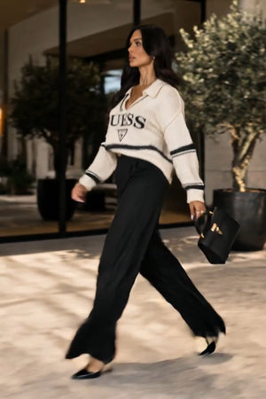 Guess Coordinato • Maglia in maglia morbida e pantaloni in tessuto fluido • Maglia oversize a righe orizzontali bianche e nere con scollo a V e colletto, abbinata a pantaloni neri a palazzo a vita alta — Eden — SHOT 2
